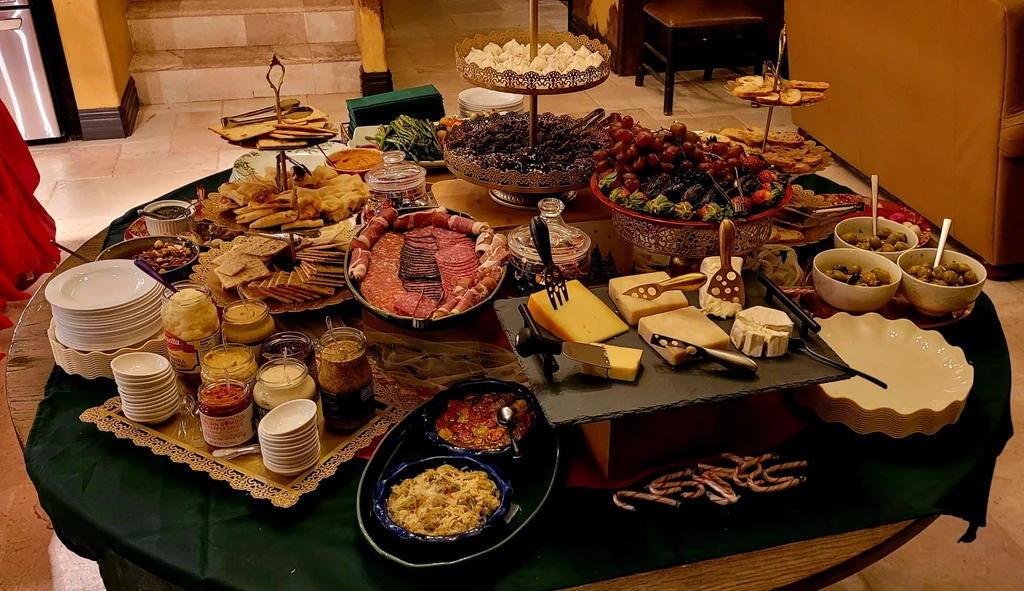 Buffet presentation with tiered displays, serving platters, bowls and stacks of plates.
